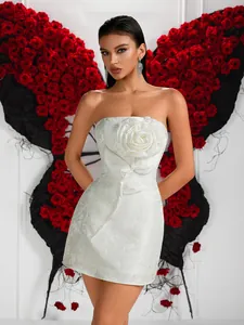 Gros plan sur une robe en jacquard blanc avec une grande fleur 3D sur la poitrine