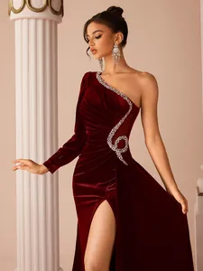 Close-up of burgundy velvet one-shoulder evening gown with rhinestone detailing