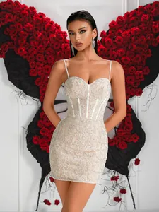 Détail d'une élégante robe courte en dentelle blanche à fines bretelles pour soirée