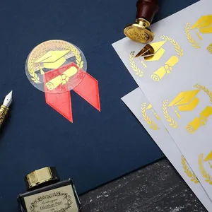 Gold graduation cap stickers used for sealing blue envelopes with elegant diploma designs.