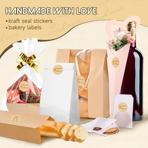 Gros plan d'autocollants kraft 'Handmade with Love' sur des sacs cadeaux et pain