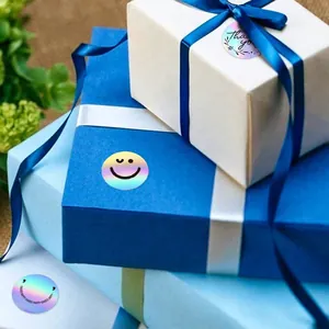 Close-up of iridescent holographic smiley and thank you round sealing stickers on gift boxes