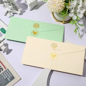 Detail of gold heart-shaped envelope seal stickers on green and cream envelopes.