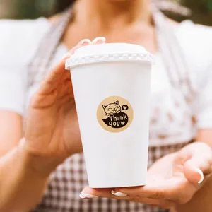 Detail van een kraftsticker met kat en Thank You op een witte koffiebeker