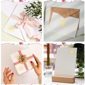 Detailed view of gold heart seal stickers on white envelopes and gift boxes