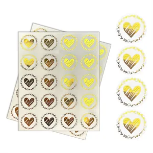Detailed view of gold foil heart envelope seal stickers with elegant floral wreaths