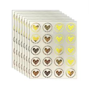Macro view of transparent gold foil heart stickers for envelope sealing and decoration