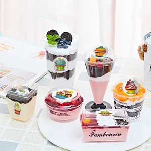 Detalle de pegatinas de cupcakes de dibujos en varios vasos de postre para decoración