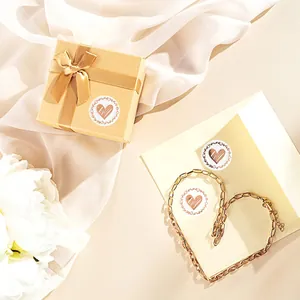 Heart-shaped gold sealing stickers for gift boxes and envelopes in a lifestyle setting