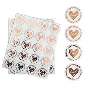 Detail view of transparent gold heart stickers with floral wreath for envelope seals.