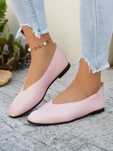 Close-up of pink minimalist ballet flats featuring pebble-grain texture and V-cut design