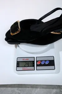 Élégante chaussure plate noire à bout pointu affichant un poids de 297 g sur balance