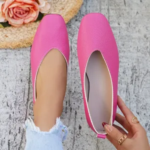 Detail view of vibrant pink pebbled leather ballet flats with square toe and white trim.