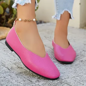 Macro view of stylish pink textured leather ballet flats for women with V-neck design