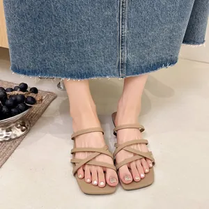 Primo piano di sandali piatti cachi con punta quadrata e cinturini sottili donna