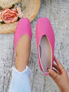 Macro view of bright pink textured faux leather ballet flats with square toe design
