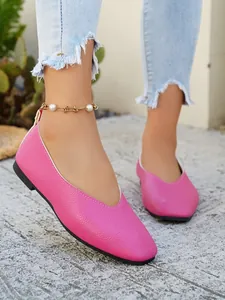 Detailed macro view of pink pebbled leather V-cut ballet flats worn with frayed denim