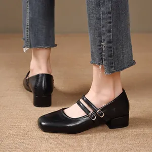 Vue détaillée des doubles brides et boucles dorées sur des chaussures Mary Jane noires