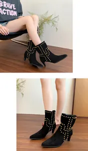 Detalle de botines de gamuza negra con punta afilada y elegantes tachuelas doradas