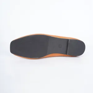 Close-up detail of the black non-slip rubber outsole on women's tan leather flats