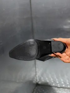 Detail van antislip rubberen zool en blokhak van puntige laarzen
