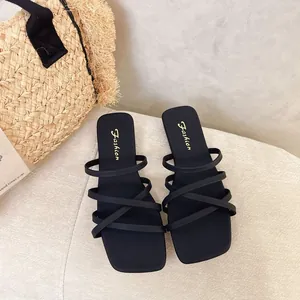 Dettaglio di sandali piatti neri multi-cinturino con punta quadrata e stile casual estivo