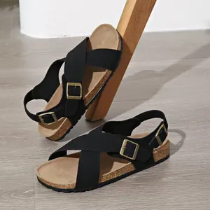 Schwarze Retro-Sandalen mit Kreuzriemen, Kork-Flachssohle und Vintage-Metallschnallen.