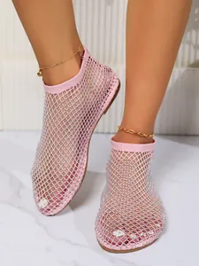 Vista dettagliata di eleganti sandali bassi a rete rosa decorati con strass lucenti.