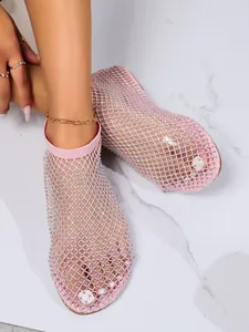 Dettaglio di sandali bassi a rete rosa decorati con molti strass scintillanti
