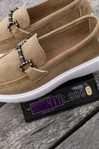 Nahansicht eines beigen Wildleder-Loafers, der auf einer Digitalwaage 417g wiegt.
