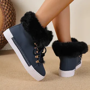 Close-up of navy blue women's snow boots with black faux fur trim and platform sole