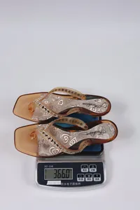 Dettaglio di infradito alla moda con stampa a cuore pesate a 366 g su una bilancia.