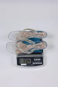 Dettaglio infradito trasparenti con strass dal peso di 372g su bilancia