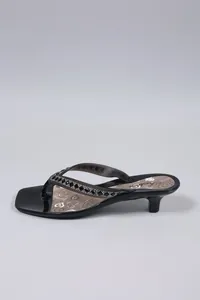 Vista laterale di eleganti sandali neri infradito con tacco gattino e cinturini con strass