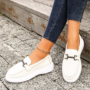 Detailansicht von cremeweißen Damen-Loafers mit Metallschnalle an einem Modell