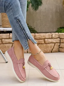 Elegant pink slip-on loafers for women shown with decorative golden bell charms