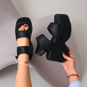 Vue détaillée des sandales compensées noires à plateforme et fermeture velcro.