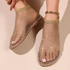 Dettaglio dei sandali piatti a rete da donna con strass e texture mesh