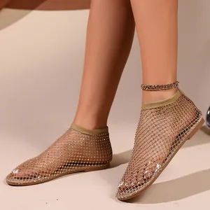 Dettaglio di sandali bassi a rete con strass scintillanti e design elegante aperto.