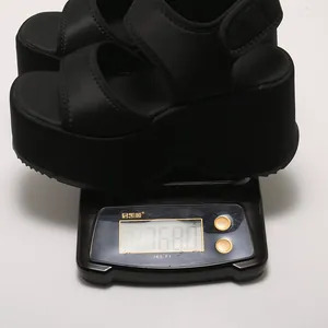 Détail de la mesure du poids d'une sandale à plateforme noire à 768,0 g sur une balance.