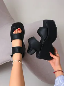 Vue détaillée de côté et de dessus de sandales compensées noires à brides velcro