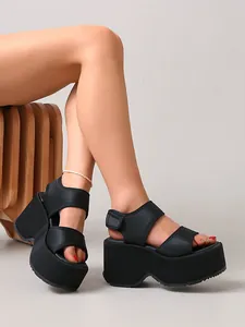 Vue latérale de sandales compensées noires à plateforme avec brides velcro.