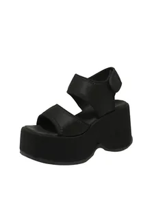 Vue de côté de sandales compensées noires élégantes avec de larges brides velcro