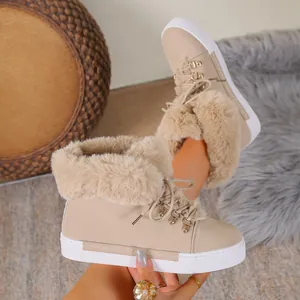 Close-up of women's beige lace-up snow boots featuring thick faux fur and platform soles.
