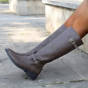 Gros plan sur des bottes cavalières marron avec boucles décoratives et talons carrés chic