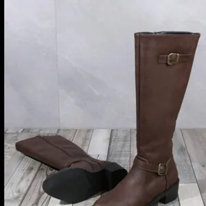 Détail de bottes cavalières marron avec sangles à boucle et petit talon carré