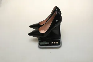 Black patent leather pointed toe stiletto pumps weight measurement on digital scale