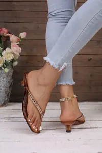 Primo piano di eleganti sandali infradito con tacco gattino e strass estivi
