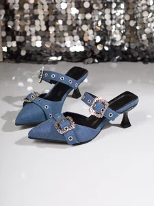 Detailansicht von Denim-Heels mit spitzer Zehenpartie und funkelnder Strassschnalle