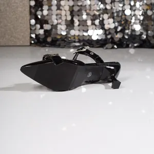 Detailaufnahme von schwarzen spitzen High Heels mit Kristall-Schnallen-Detail
